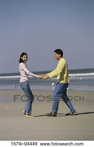 Stock Photo - Young couple playing on the beach. Fotosearch