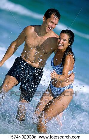Young couple running on the beach View Large Photo Image Stock Image - Young couple running on the beach. Fotosearch