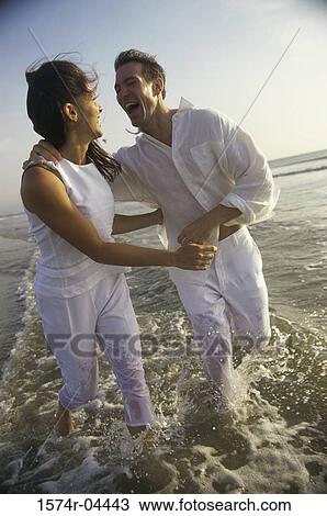 Young couple running on the beach View Large Photo Image Stock Image - Young couple running on the beach. Fotosearch