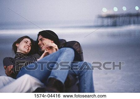 Young couple sitting on a couch on the beach View Large Photo Image Stock Photograph - Young couple sitting on a couch on the beach. Fotosearch