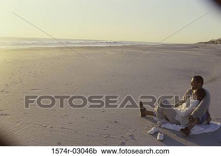 Young couple sitting on the beach View Large Photo Image Stock Image - Young couple sitting on the beach. Fotosearch