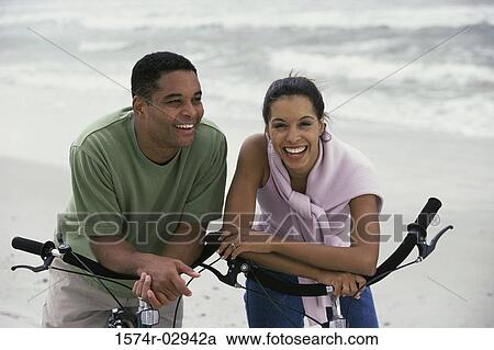 Stock Image - Young couple with bicycles on the beach. Fotosearch