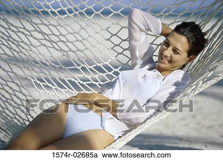 Young woman lying in a hammock View Large Photo Image Stock Image - Young woman lying in a hammock. Fotosearch