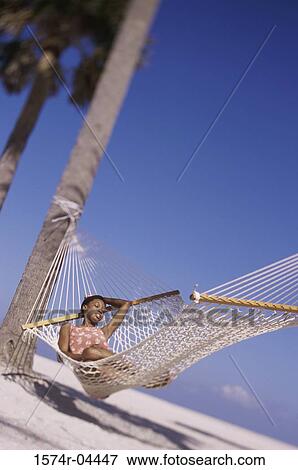 Young woman lying in a hammock View Large Photo Image Stock Photo - Young woman lying in a hammock. Fotosearch
