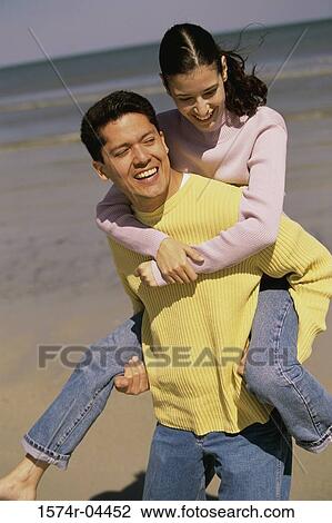 Young woman riding piggyback on a young man on the beach View Large Photo Image Stock Image - Young woman riding piggyback on a young man on the beach. Fotosearch