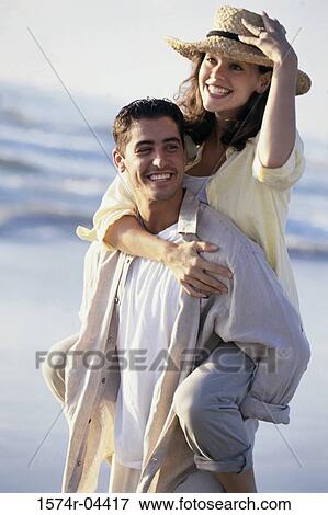 Young woman riding piggyback on a young man on the beach View Large Photo Image Stock Photo - Young woman riding piggyback on a young man on the beach. Fotosearch