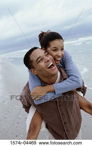 Young woman riding piggyback on a young man on the beach View Large Photo Image Stock Photo - Young woman riding piggyback on a young man on the beach. Fotosearch