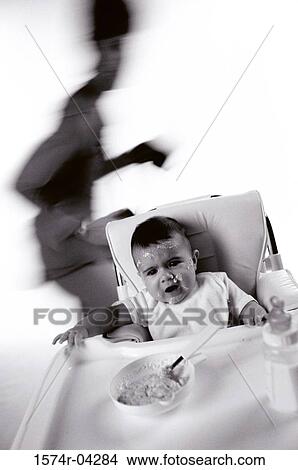 Baby boy sitting on a highchair View Large Photo Image Picture - Baby boy sitting on a highchair. Fotosearch