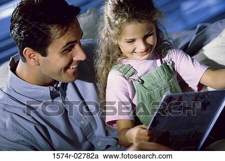 Close-up of a father and his daughter reading a book View Large Photo Image Stock Image - Close-up of a father and his daughter reading a book. Fotosearch