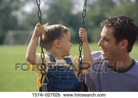 Close-up of a father and his son playing on a swing View Large Photo Image Stock Image - Close-up of a father and his son playing on a swing. Fotosearch