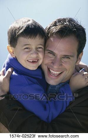 Close-up of a father hugging his son View Large Photo Image Stock Image - Close-up of a father hugging his son. Fotosearch