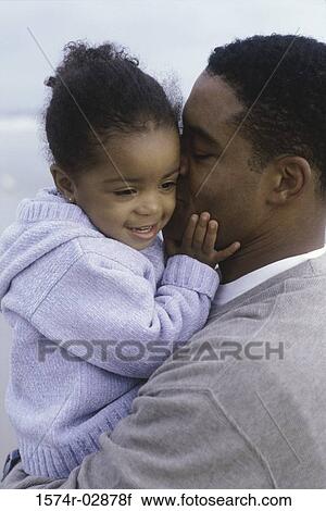 Stock Image - Close-up of a father kissing his daughter. Fotosearch