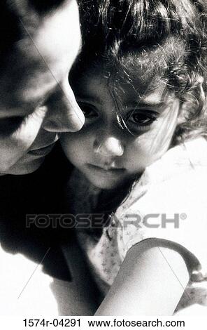 Stock Image - Close-up of a mother hugging her daughter. Fotosearch