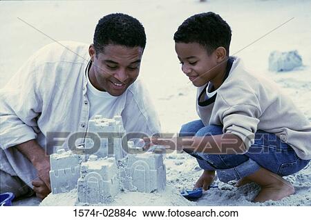 Father and his son making sand castles on the beach View Large Photo Image Stock Image - Father and his son making sand castles on the beach. Fotosearch
