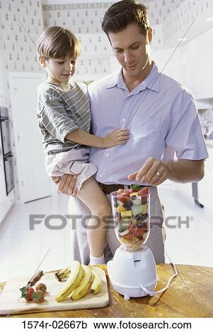 Stock Image - Father and son making a fruit shake. Fotosearch