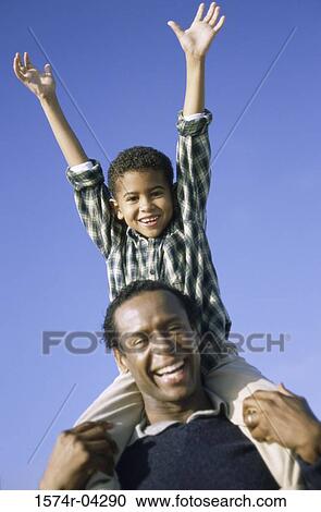 Father carrying his son on his shoulders View Large Photo Image Stock Image - Father carrying his son on his shoulders. Fotosearch