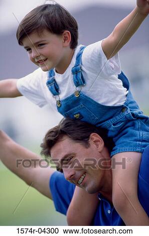 Stock Image - Father carrying his son on his shoulders. Fotosearch