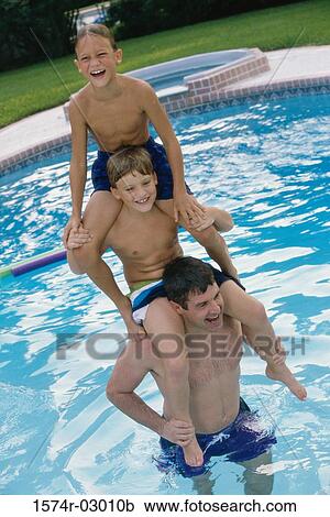 Father in a swimming pool with his two sons sitting on his shoulders View Large Photo Image Stock Image - Father in a swimming pool with his two sons sitting on his shoulders. Fotosearch