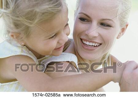 Girl riding piggyback on her mother View Large Photo Image Stock Image - Girl riding piggyback on her mother. Fotosearch