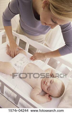 High angle view of a mother looking at her baby boy in a crib View Large Photo Image Picture - High angle view of a mother looking at her baby boy in a crib. Fotosearch