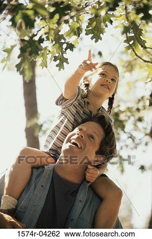 Low angle view of a girl sitting on her father's shoulders View Large Photo Image Stock Image - Low angle view of a girl sitting on her father's shoulders. Fotosearch