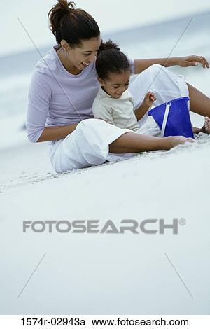 Mother and her daughter playing together on the beach View Large Photo Image Stock Image - Mother and her daughter playing together on the beach. Fotosearch