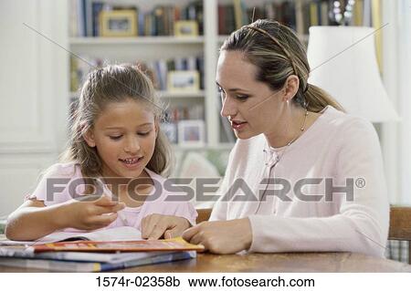 Mother assisting her daughter with her homework View Large Photo Image Stock Image - Mother assisting her daughter with her homework. Fotosearch