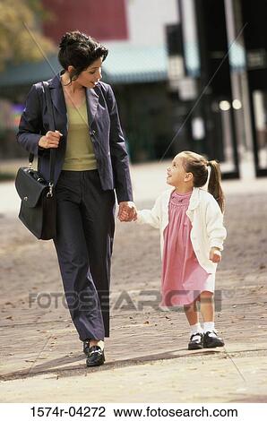 Mother holding hands while walking with her daughter View Large Photo Image Stock Image - Mother holding hands while walking with her daughter. Fotosearch