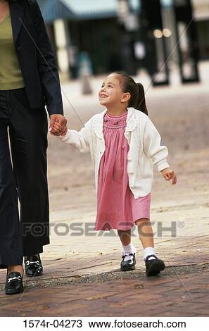 Mother holding hands while walking with her daughter View Large Photo Image Stock Image - Mother holding hands while walking with her daughter. Fotosearch