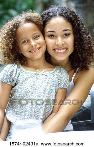 Stock Image - Mother hugging her daughter. Fotosearch