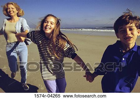 Portrait of a mother running on the beach with her son and daughter View Large Photo Image Stock Photography - Portrait of a mother running on the beach with her son and daughter. Fotosearch