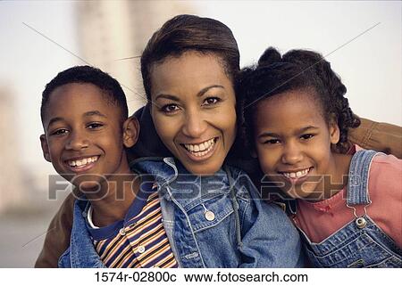 Stock Image - Portrait of a mother smiling with her son and daughter. Fotosearch