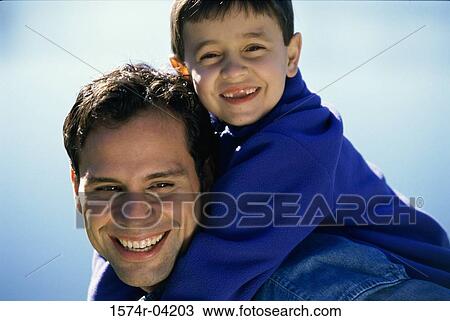 Portrait of a son riding piggyback on his father View Large Photo Image Stock Image - Portrait of a son riding piggyback on his father. Fotosearch