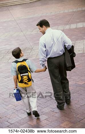Stock Image - Rear view of a father and his son holding hands. Fotosearch