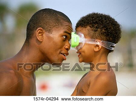 Side profile of a father and his son looking at each other View Large Photo Image Picture - Side profile of a father and his son looking at each other. Fotosearch