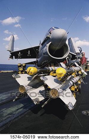 Stock Photo - Arming of an A-7E Corsair II with AIM-9 Sidewinder Missiles and Mark 82 Bombs. Fotosearch