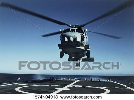 Stock Photo - Low angle view of a SH-60B Sea Hawk helicopter landing on the deck of an aircraft carrier. Fotosearch