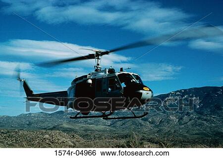 Stock Photograph - Low angle view of a UH-1 Iroquois in flight. Fotosearch