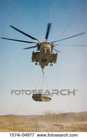 Stock Photo - Low angle view of CH-53D Sea Stallion lifting a tank. Fotosearch