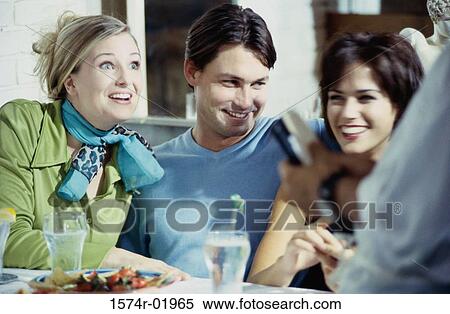Close-up of a young man in a cafe with two young women View Large Photo Image Stock Photography - Close-up of a young man in a cafe with two young women. Fotosearch