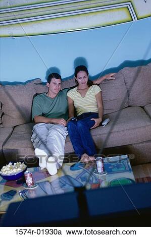 High angle view of a couple sitting on a couch and watching television View Large Photo Image Stock Image - High angle view of a couple sitting on a couch and watching television. Fotosearch