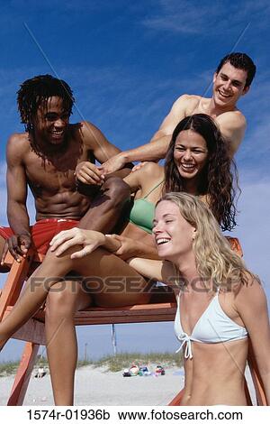Low angle view of a group of teenagers sitting on a lifeguard tower View Large Photo Image Stock Image - Low angle view of a group of teenagers sitting on a lifeguard tower. Fotosearch