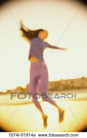 Low angle view of a young woman dancing View Large Photo Image Stock Image - Low angle view of a young woman dancing. Fotosearch