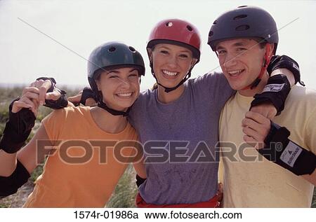 Portrait of a group of three teenagers wearing helmets smiling View Large Photo Image Stock Image - Portrait of a group of three teenagers wearing helmets smiling. Fotosearch