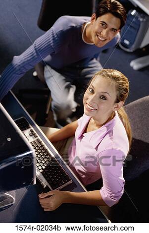Portrait of a young man and a young woman sitting in a computer class View Large Photo Image Stock Image - Portrait of a young man and a young woman sitting in a computer class. Fotosearch
