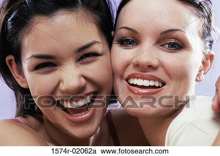 Stock Image - Portrait of two young women smiling. Fotosearch