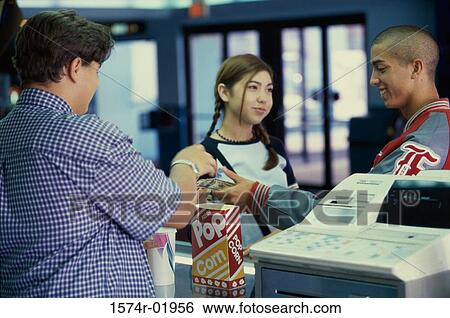 Teenage couple buying popcorn in a movie theater View Large Photo Image Stock Photograph - Teenage couple buying popcorn in a movie theater. Fotosearch