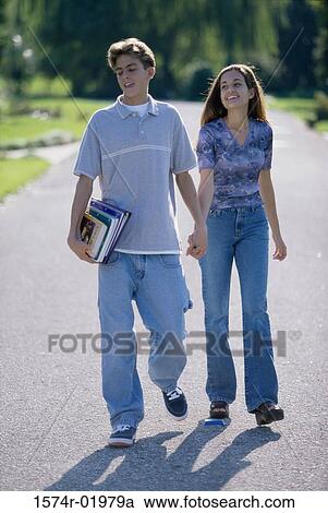 Teenage couple holding hands walking outdoors View Large Photo Image Stock Image - Teenage couple holding hands walking outdoors. Fotosearch