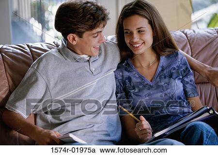 Teenage couple sitting together on a couch View Large Photo Image Stock Image - Teenage couple sitting together on a couch. Fotosearch