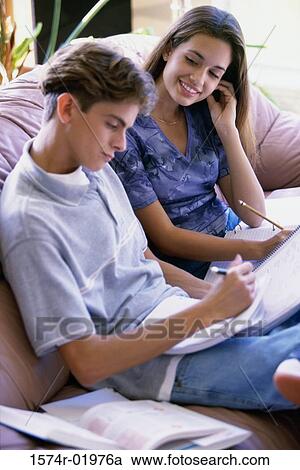 Teenage couple sitting together on a couch View Large Photo Image Stock Image - Teenage couple sitting together on a couch. Fotosearch